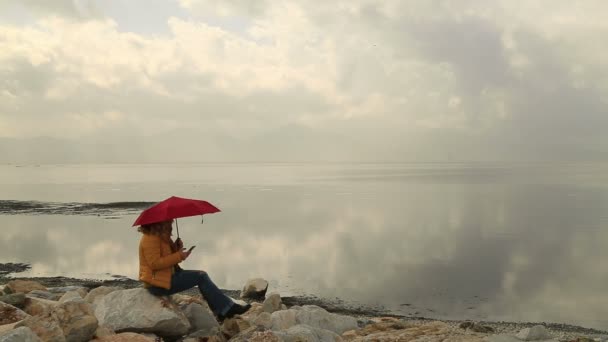 Femme avec parapluie utilisant un téléphone intelligent — Video