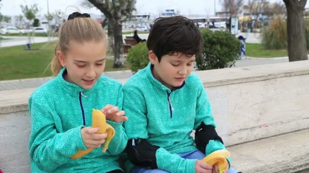 Jonge schaatsers eten van banaan — Stockvideo