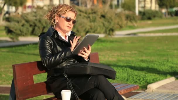 Mulher de negócios ocupada trabalhando na pausa para almoço em um parque — Vídeo de Stock