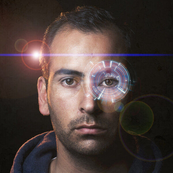Futuristic portrait of a young man with a hologram in one eye and movie like lens flare