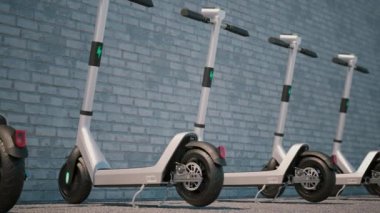 Kamera animasyonu ve arka arkaya park etmiş modern elektrikli scooterlar. Tuğla duvarın yanında elektrikli scooterlar. Şehir motorsiklet paylaşım konsepti. Döngüye bağlı yüksek kalite 3 boyutlu animasyon. ProRes.
