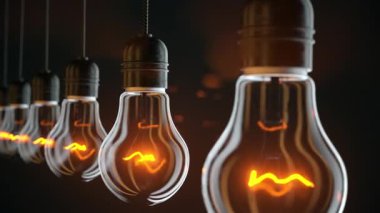 Bir sıra asılmış klasik akkor ampuller. Fikir, yenilik, yaratıcılık ve enerji kavramları için mükemmel. Ultra HD 4K 3840x2160 4K döngüsel animasyon