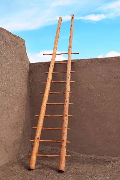 Escada de madeira para o céu apoiando-se na parede adobe Taos Pueblo — Fotografia de Stock