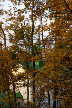 Kilisenin arka planında sonbahar ağaçları