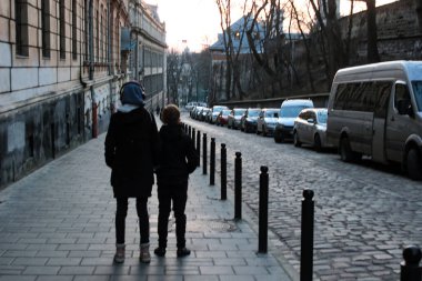 Kız ve adam eski kasabanın caddesinde yürüyorlar. 