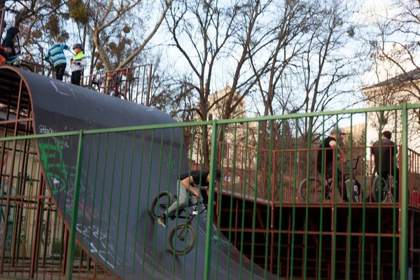 Gençler parkta hız trenlerinde scooter ve bisiklete biniyorlar.