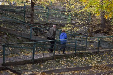 Baba oğluyla parkta yürüyor ve iletişim kuruyor.