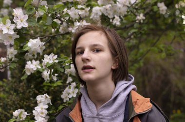 Kız çiçek açan elma ağacının arasında mutlu.