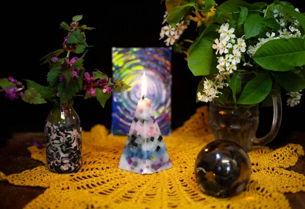 静谧的生活 有一支燃烧的蜡烛 一个盛满白花的花瓶 一个紫色的条件和一个玻璃球 — 图库照片
