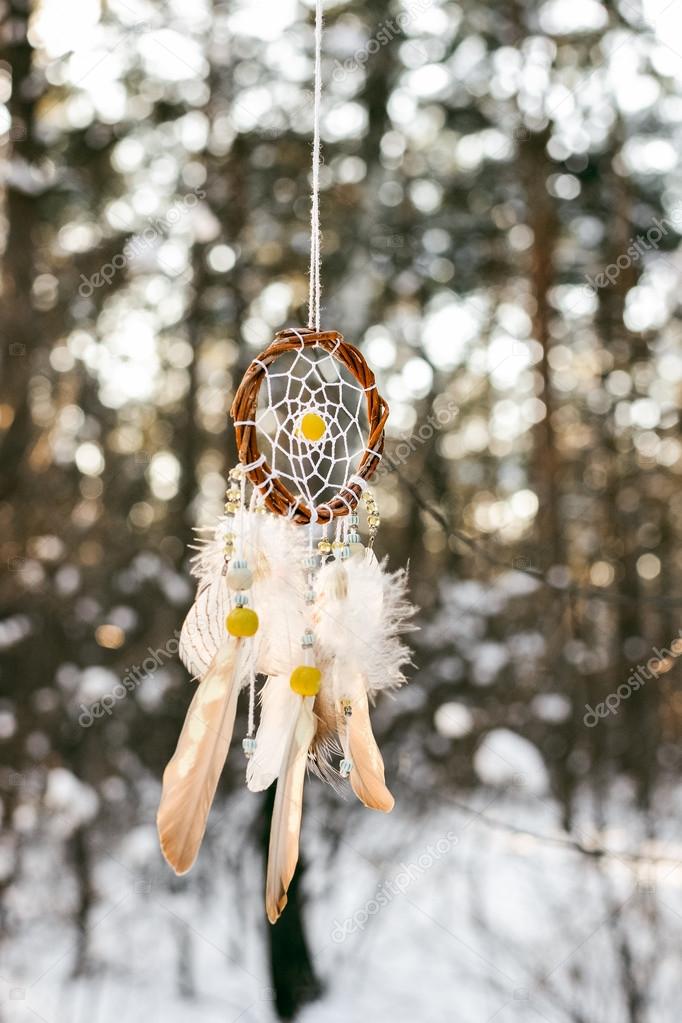 Handmade colorfull dream catcher in the snowy forest