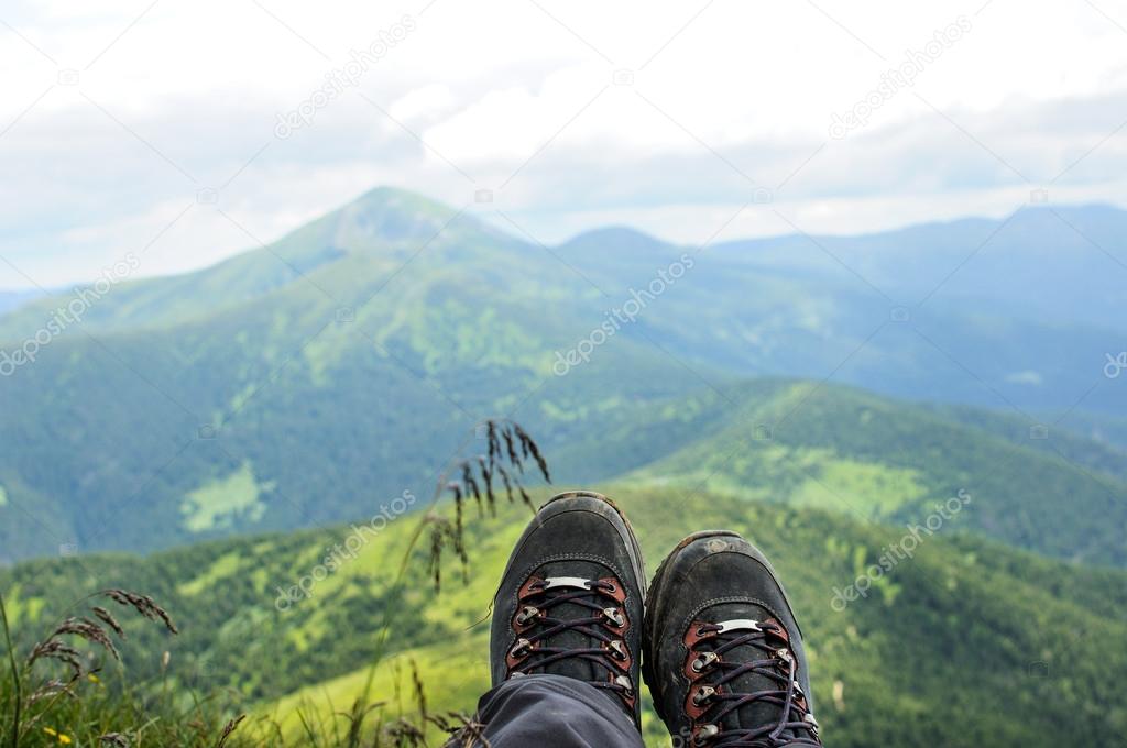 Hiking boots of traveler sitting on high mountain top