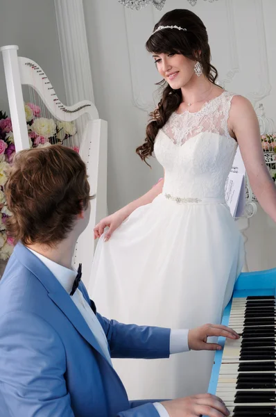 Portraits of beautiful woman and man playing on piano — Stock Photo, Image