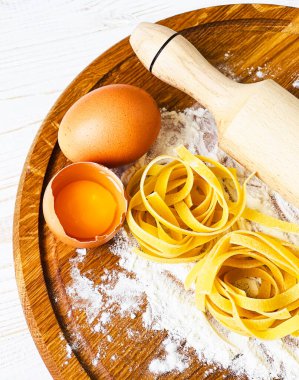 Tahta bir masada yumurta makarna ve un.