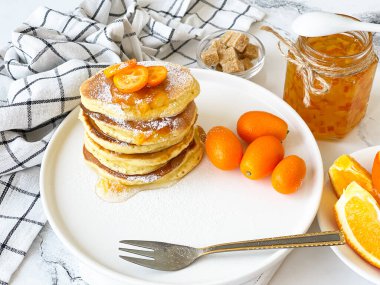 Kahvaltıda portakal reçelli gözleme ve kumkat, beyaz bir masada.