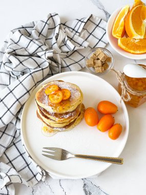 Kahvaltıda portakal reçelli gözleme ve kumkat, beyaz bir masada.