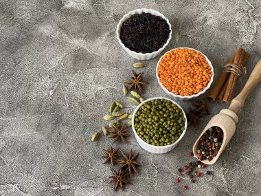 Esmer pirinç, mercimek, fasulye, biber, anason ve kakule gri betonda.