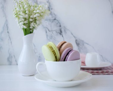 Bir kapta badem kurabiyesi ve vadideki zambaklar