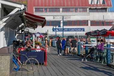 Guilford, BC, Kanada 'daki restoranların açık alanlarında oturan insanların sokak görüntüsü. 18 Nisan 2021. Sokak manzarası, seyahat fotoğrafı, seçici odak.