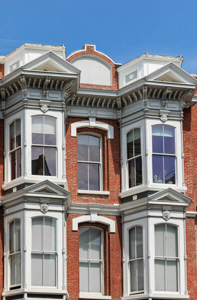 Old Victorian style exterior design windows of the house in old city Victoria, BC, Canada. July 23,2021. Street view, travel photo, selective focus, concept photo architexture