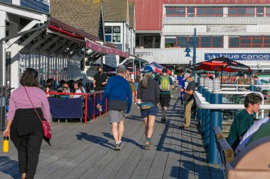 Guilford, BC, Kanada 'daki restoranların açık alanlarında yürüyen ve oturan insanların sokak görüntüsü. 18 Nisan 2021. Sokak manzarası, seyahat fotoğrafı, seçici odak.