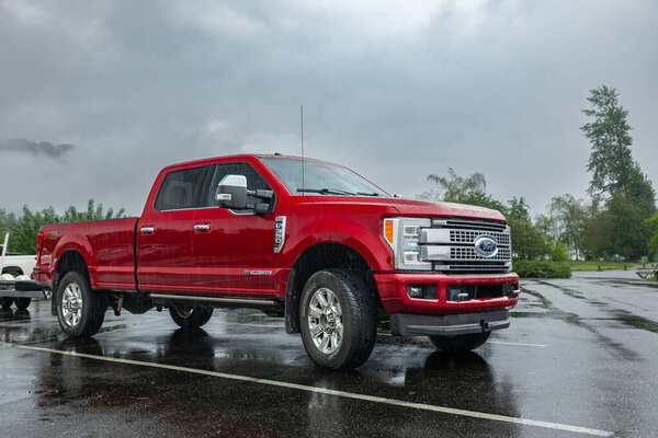 Super duty truck. Red Ford F350 Platinum pick up truck parked on the parking lot in the rural on a rainy day. Nobody-Vancouver Canada-Jun 3,2022