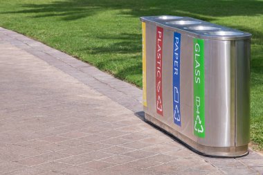 Sokaklarda çöp tenekelerini düzenliyorlar. Kamu parkında kağıt, şişe, kutu ve plastik için geri dönüşüm kutuları. Çöp bidonları ve çeşitli çöpler. Çöp Kutuları Geri Dönüşüm Koleksiyonu. Kimse.