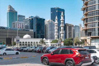 Abu Dabi şehir merkezi, UAE silueti ve modern binalar, konut evleri ve oteller, otoparkında arabaları olan cami. Konut kompleksindeki daireler. Seyahat fotoğrafı: 19 Nisan 2025