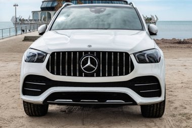 Küçük Mercedes-Benz marka beyaz arabaları kapatın. Durres Arnavutluk plajı yakınındaki beyaz Mercedes SUV 'nin ön manzarası. Lüks SUV Mercedes Benz sınıfı GLE-April 1,2025