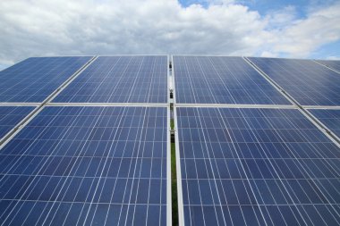 Güneş panelleri güneş ışığı bulutlar ve gökyüzü karşı gelen elektrik üretmek için kullanılır. Yakın çekim.