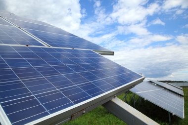 Bulutlar ve gökyüzü karşı ışığından elektrik üretmek için kullanılan güneş panelleri.