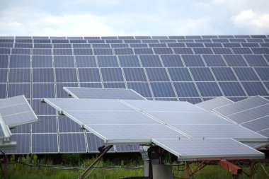 Bulutlar ve gökyüzü karşı ışığından elektrik üretmek için kullanılan güneş panelleri.
