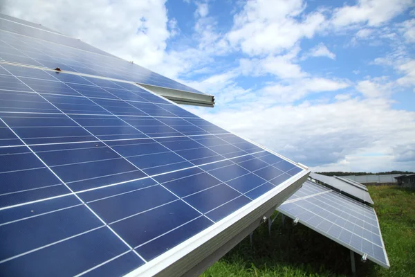 Bulutlar ve gökyüzü karşı ışığından elektrik üretmek için kullanılan güneş panelleri.