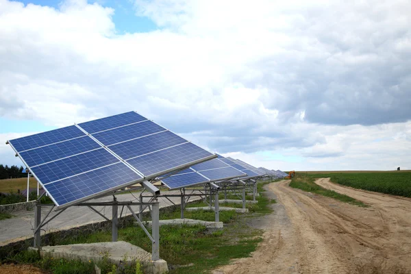 Сонячні панелі біля сільської дороги. Монтаж сонячних панелей в сільській місцевості . — стокове фото