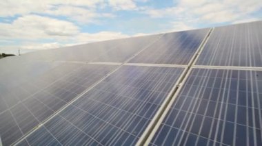 Bulutlar ve gökyüzü karşı ışığından elektrik üretmek için kullanılan güneş panelleri.
