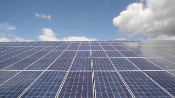 Солнечный свет светит от солнечных батарей в поле. Солнечные панели, используемые для выработки электроэнергии из солнечного света против облаков и неба - Stock Video — стоковое видео
