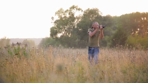 Photohunt. Onun bu işle akşam güneşin fotoğrafçı. — Stok video