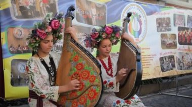 VINNYTSIA, UKRAINE - 11 Eylül 2021: Ulusal Ukrayna kostümlü genç kızlar bandura çalıyorlar. Bandura, Ukrayna müzik aleti. Şehrin caddelerinde kutlamalar yapılıyor. Şehir tatili. 