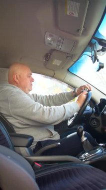 Alkollü araç kullanma. Sürücü araba sürerken güçlü bir alkollü içecek içiyor. Sürücü dikey video kullanırken sert alkol kullanıyor..