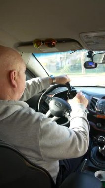 Alkollü araç kullanma. Sürücü araba sürerken güçlü bir alkollü içecek içiyor. Sürücü dikey video kullanırken sert alkol kullanıyor..