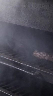 Et lokantası. Biftekler Josper fırınında kızartılır. Bir josper 'da biftek kızartmak - Dikey video.