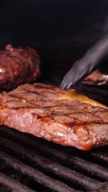 Et lokantası. Biftekler Josper fırınında kızartılır. Bir josper 'da biftek kızartmak - Dikey video.