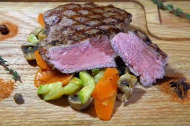 Sığır eti biftek pişmiş sebze yastık üzerinde. Sığır eti biftek ahşap plaka plaka üzerinde. -Stok görüntü