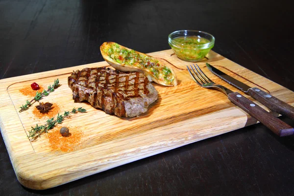 Bistec de res medio raro en cojín vegetal. Carne de res en plato de madera - Stock Image — Foto de Stock