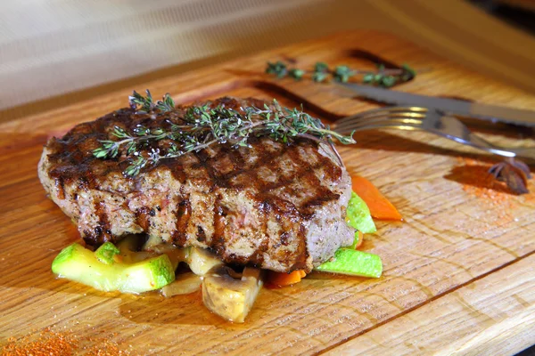 Bistec de res medio raro en cojín vegetal. Carne de res en plato de madera. - Imagen de stock — Foto de Stock