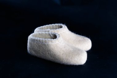 Yünden yapılmış terlikler, işleme yöntemiyle işlenmiş.