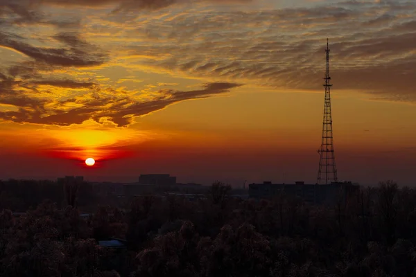 Batan güneş ve Cheboksary şehrindeki TV kulesi, kış akşamı.