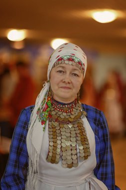 Cheboksary, Chuvashia / Rusya-10.11.2019-Ulusal Udmurt kostümlü bir kadın, bir folklor topluluğu parçası olarak ulusal kültür festivaline geldi.