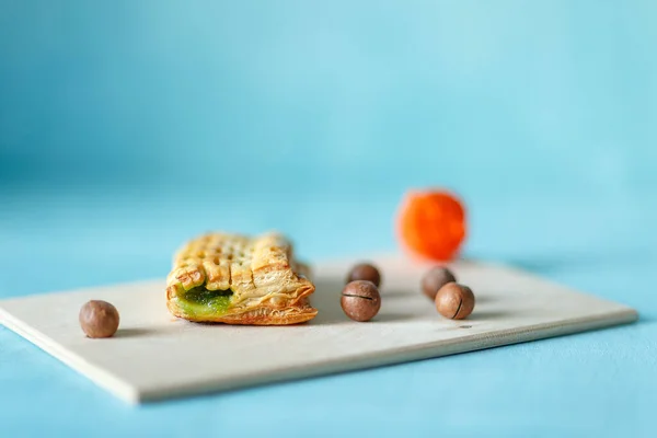 kiwi puff ve macadamia fındıkları ahşap tepside mavi arka planda