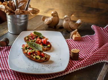 iki bruschette domates, salatalık ve yeşil yaprak bir masa üzerinde beyaz bir tabakta