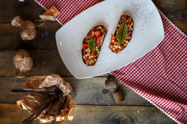 iki bruschette domates, salatalık ve yeşil yaprak bir masa üzerinde beyaz bir tabakta
